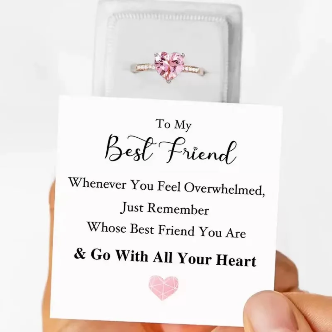 Ring with pink gemstone in a jewelry pouch, held by a hand with a card reading 'To My Best Friend' message.